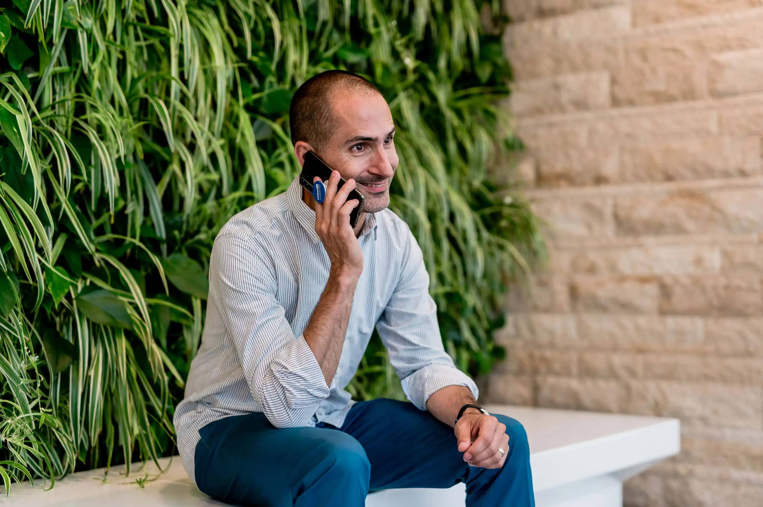 Das Bild zeigt einen erfolgreichen Geschäftsmann, der telefoniert und sich in einem modernen, grünen Umfeld befindet. Fotografin Mica Zeitz, eine erfahrene Businessfotografin und Fotografenmeisterin aus Ingolstadt, kreiert eindrucksvolle Referenzbilder für LinkedIn und andere professionelle Plattformen.