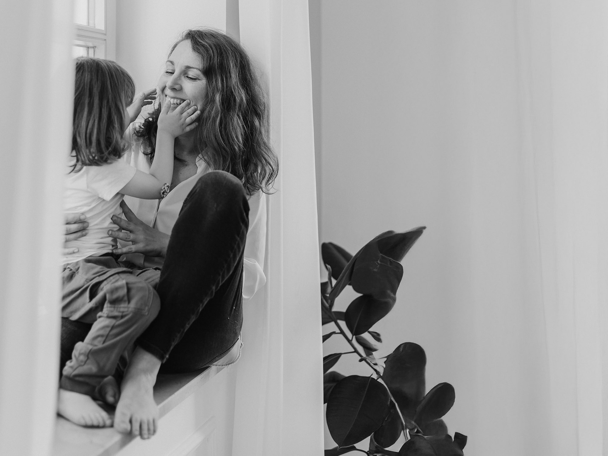 Das berührende Schwarzweißbild von Mica Zeitz zeigt die innige Beziehung zwischen einer Mutter und ihrem Kind, festgehalten in einem harmonischen Moment. Als erfahrene Fotografenmeisterin und Hochzeits- sowie Peoplefotografin in Bayern schafft sie unvergessliche Erinnerungen, die Emotionen und Verbundenheit widerspiegeln.