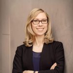 Das Bild zeigt eine selbstbewusste Frau mit Brille, die in einem professionellen Umfeld posiert, aufgenommen von der Fotografin Mica Zeitz. Diese Aufnahme spiegelt die Werte der verturis GmbH wider, die für innovative Lösungen und professionelle Dienstleistungen steht.